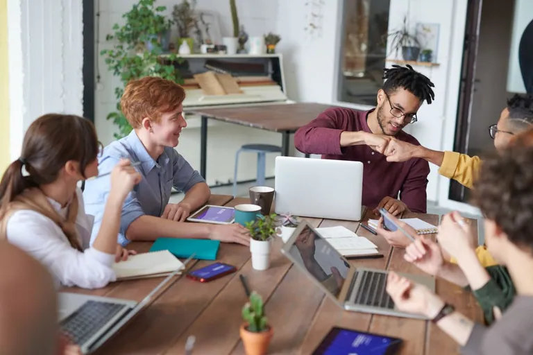 Corporate team collaborating around a laptop in a modern office